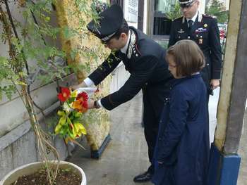 Il capitano Del Giacomo ed una bambina della Morvillo mettono fiori sul monumento ai caduti