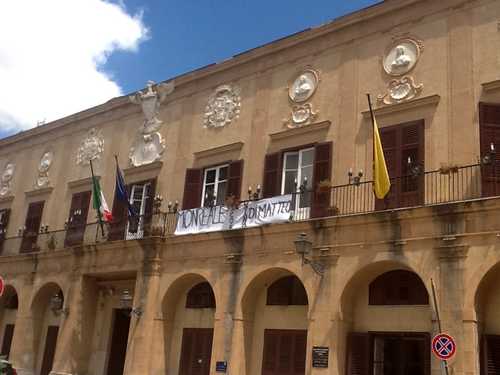 Lo striscione appeso al balcone del municipio